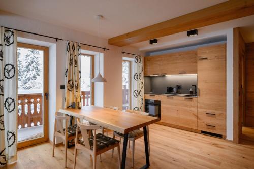 a dining room with a wooden table and a kitchen at Vila Pavlina in Kranjska Gora