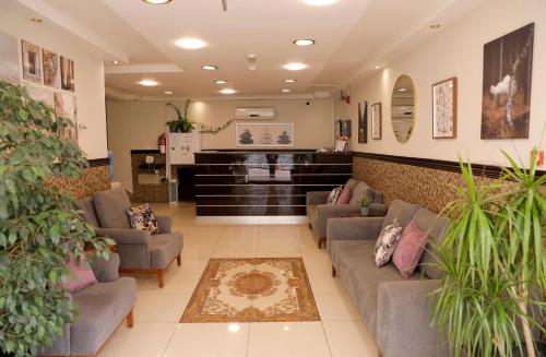 a waiting room with couches and potted plants at Abu Alsoud Hotel in Amman