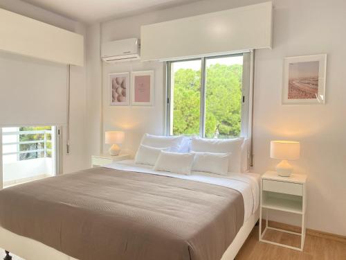 een witte slaapkamer met een groot bed met witte kussens bij Phaedrus Living Down Town Flat Stephania 302 in Limassol