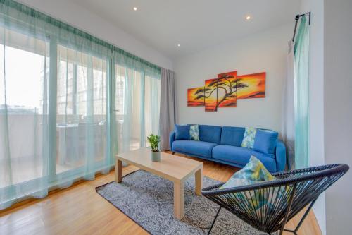 - un salon avec un canapé bleu et une table dans l'établissement Sapphire Residences - Apartments & Penthouse In Central Sliema By Shortletsmalta, à Sliema