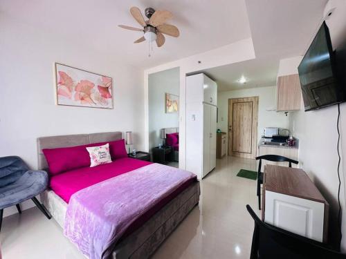 um quarto com uma cama grande e um cobertor rosa em Lengs Place 1 - Studio Unit at Inspiria Condo Beside Abreeza Mall Davao City em Dávao