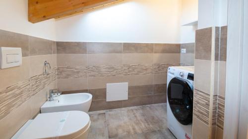 a bathroom with a toilet sink and a washing machine at Casa Degli Artigiani-Attico con vista in Oristano