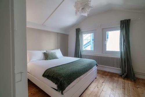 um quarto com uma cama e uma janela em Mansarda Verde by Quokka 360 - cosy attic apartment with lake view em Ponte Tresa