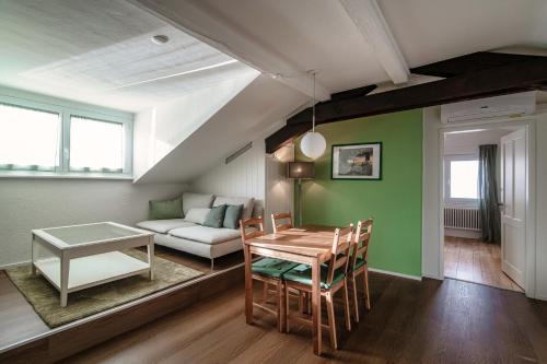 uma sala de estar com uma mesa e um sofá em Mansarda Verde by Quokka 360 - cosy attic apartment with lake view em Ponte Tresa