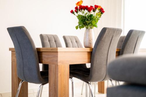 un tavolo in legno con sedie e un vaso di fiori di Sebastian Apartment & Studio RHODOS a Afantou