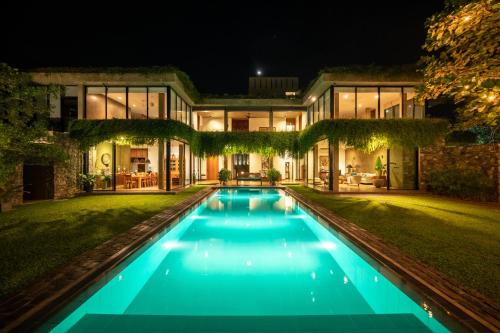 a house with a swimming pool at night at Tranquil Waters in Negombo