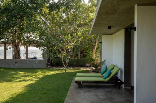a green chair sitting on a patio next to a yard at Tranquil Waters in Negombo