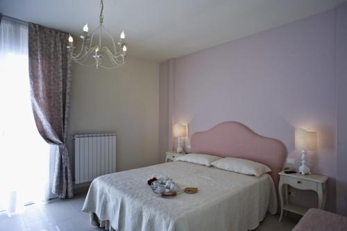 a bedroom with a large bed with a pink headboard at Cevoli Country Resort in Lari