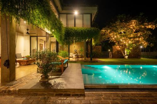 a swimming pool in the yard of a house at night at Tranquil Waters in Negombo