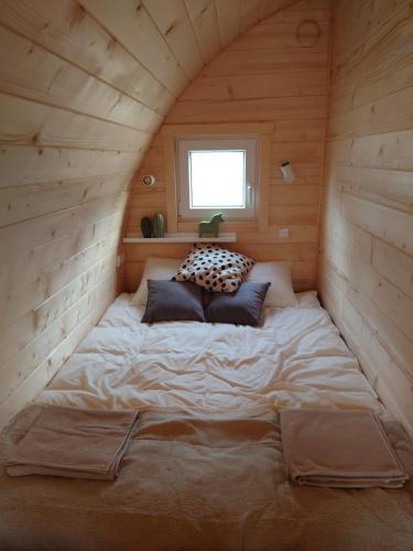 a bed in the corner of a room in a cabin at Hobbit Hut in Hallstahammar