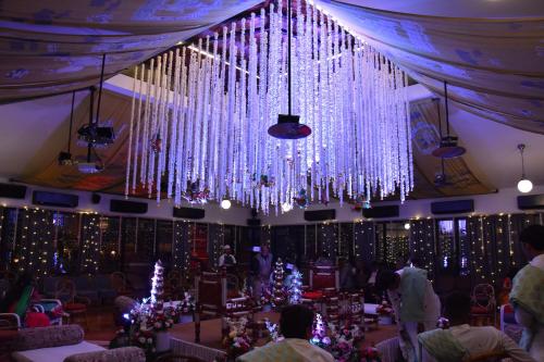 a large room with christmas trees and a chandelier at The House of MG-A Heritage Hotel, Ahmedabad in Ahmedabad