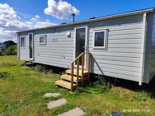 a silver caravan with a staircase leading to the door at mini-camping 't Bergje in Serooskerke