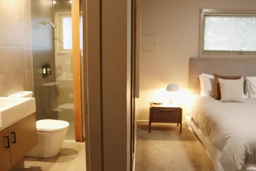 um quarto com uma cama e uma casa de banho com um lavatório em Hepburn hideaway studio em Hepburn Springs