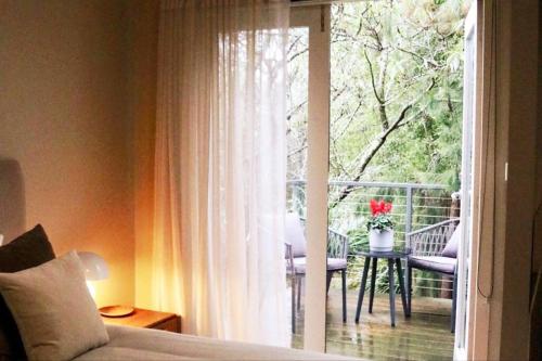 um quarto com uma janela e uma varanda com uma mesa em Hepburn hideaway studio em Hepburn Springs