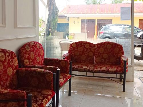 two chairs and a couch in a store window at Reddoorz @ Kanaka GuestHouse in Bengkulu