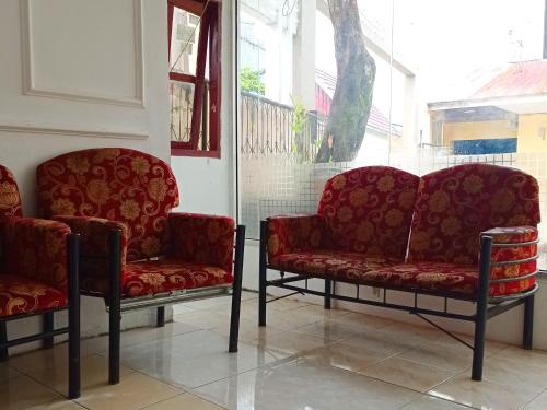 two red chairs sitting next to a window at Reddoorz @ Kanaka GuestHouse in Bengkulu