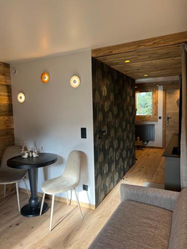 een woonkamer met een tafel en een bank bij Studio Chalet des Pistes Megève in Demi-Quartier