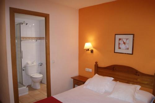1 dormitorio con 1 cama y baño con aseo en Hostal Cal Batista, en Bagá