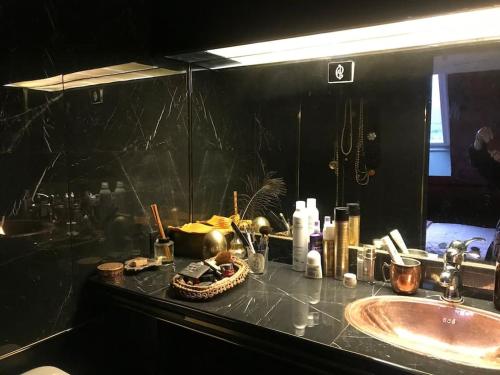 um balcão de casa de banho com um lavatório e um espelho em A writer's flat em Paris