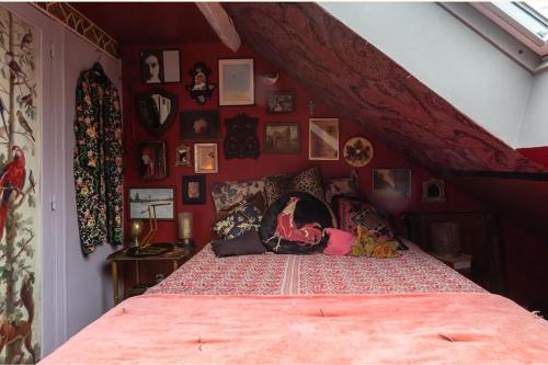 - une chambre avec un grand lit et un mur rouge dans l'établissement A writer's flat, à Paris