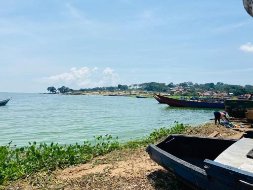 ein Boot am Ufer eines Wasserkörpers in der Unterkunft HomeOnTheNile Lake view double in Jinja