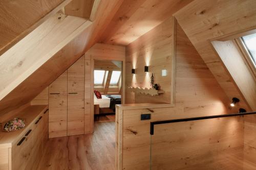 an attic room with a staircase in a wooden house at Vila Pavlina in Kranjska Gora
