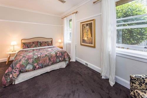 une chambre avec un lit et une grande fenêtre dans l'établissement Centennial Cottage 2 - Botanica, à Bowral