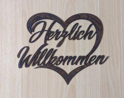 um sinal com um coração numa parede de madeira em Landhaus "Kühler Morgen", Appartement mit 140er Futonbett, Teeküche, Bad 
