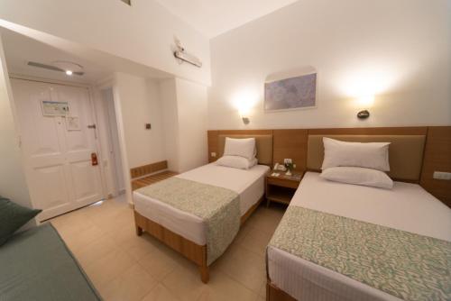 a hotel room with two beds and a door at Dahab Lagoon Club & Resort Ex Tirana Dahab in Dahab