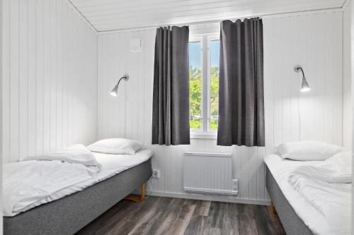 1 dormitorio con 2 camas y ventana en First Camp Tylösand-Halmstad, en Tylösand