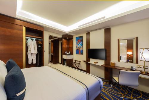 a hotel room with a bed and a television at Blue Diamond Hotel Jeddah in Jeddah
