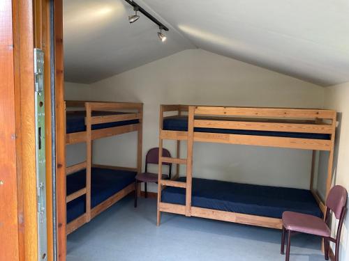 a room with three bunk beds in a house at Trekker Hut in Tyndrum