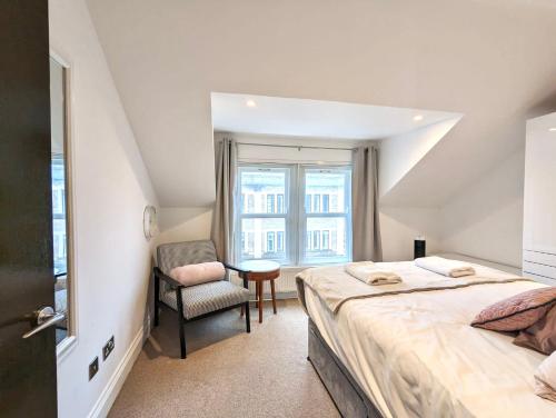 ケンブリッジにあるKoala & Tree - 1 & 2 bed apartments in Cambridge city centre Short Lets & Serviced Accommodationのベッドルーム1室(ベッド1台、椅子、窓付)