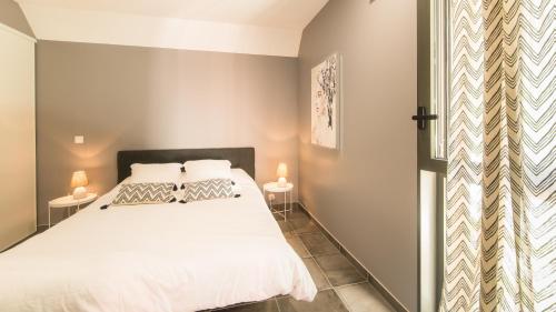 - une chambre avec un lit blanc et deux lampes dans l'établissement La chambre Cosy, à Sarlat-la-Canéda