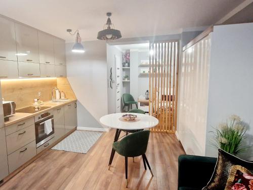 a kitchen and dining room with a table and chairs at Promenada Room Ełk in Ełk