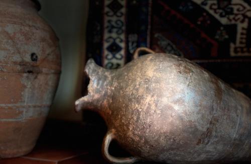 a metal vase sitting on a table with other vases at Saryan Guesthouse in Goris