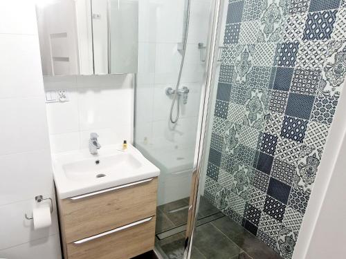 W łazience znajduje się umywalka i prysznic. w obiekcie Promenada Room Ełk w mieście Ełk
