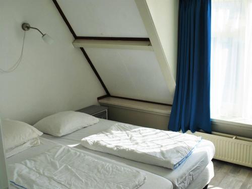 1 dormitorio con 2 camas y ventana en Vakantiehuis Seahorse en Egmond aan Zee