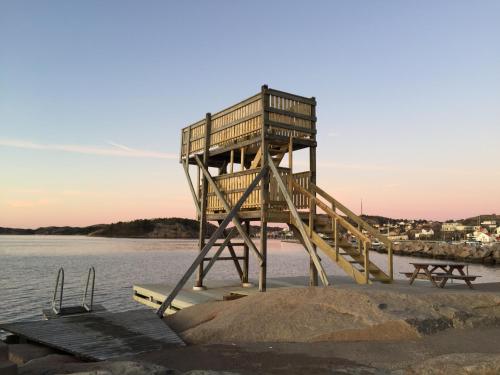 a lifeguard tower sitting on the beach next to the water at Badholmens Vandrarhem in Fjällbacka