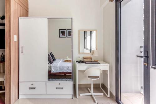 a bedroom with a mirror and a desk with a chair at Shore 2 Apartment with Balcony in Manila