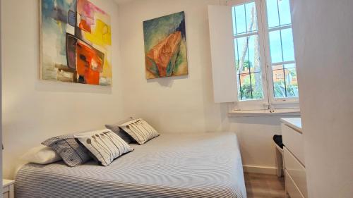 un letto in una stanza con due dipinti sul muro di Casa con jardín a 30 metros de la playa. VL. a Palamós