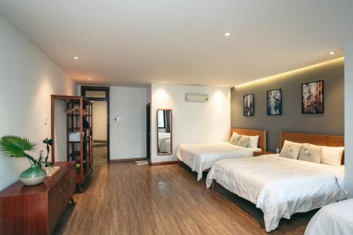 a hotel room with two beds and a mirror at Kool House in Tuy Hoa