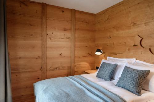 a bedroom with wooden walls and a bed with blue pillows at Vila Pavlina in Kranjska Gora