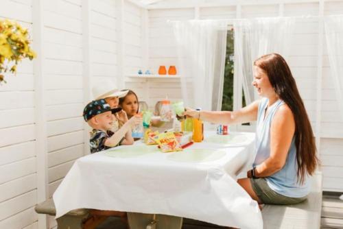a woman and two children sitting at a table eating food at Guesthouse Torppa in Korkeakoski