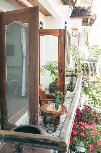 a mirror on a porch with a table and flowers at Kool House in Tuy Hoa
