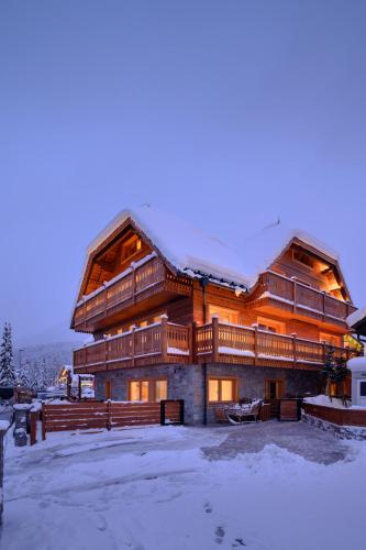 a large wooden house with snow on it at Vila Pavlina in Kranjska Gora
