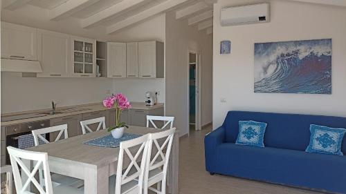uma cozinha e sala de estar com uma mesa e um sofá azul em Welcomely - White Terrace - Condominio AcquaLife em Cannigione