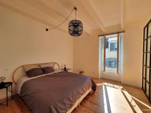 une chambre avec un grand lit et une fenêtre dans l'établissement Maison de ville - Plage à pied, à Crozon