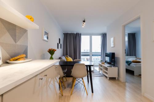 a kitchen and living room with a table and chairs at ShortStayPoland Grzybowska (B73) in Warsaw