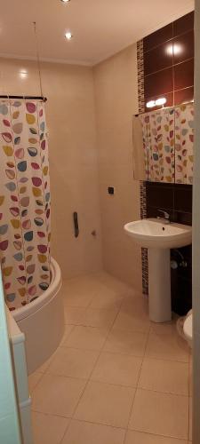 a bathroom with a sink and a shower curtain at Bugibba Homes Suite in St Paul's Bay
